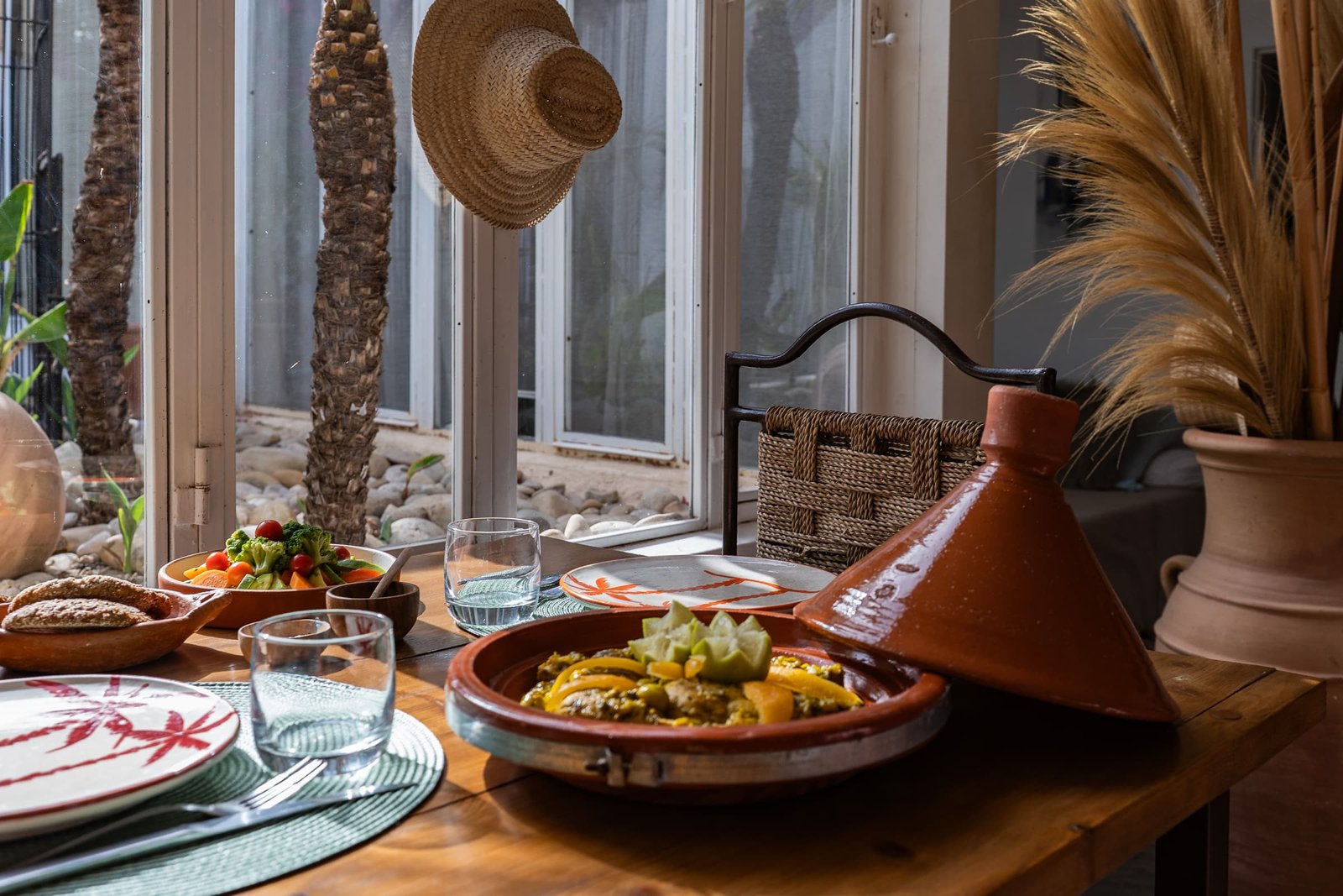 Un tajine de légumes servi sur la table en bois, salade et pain maison