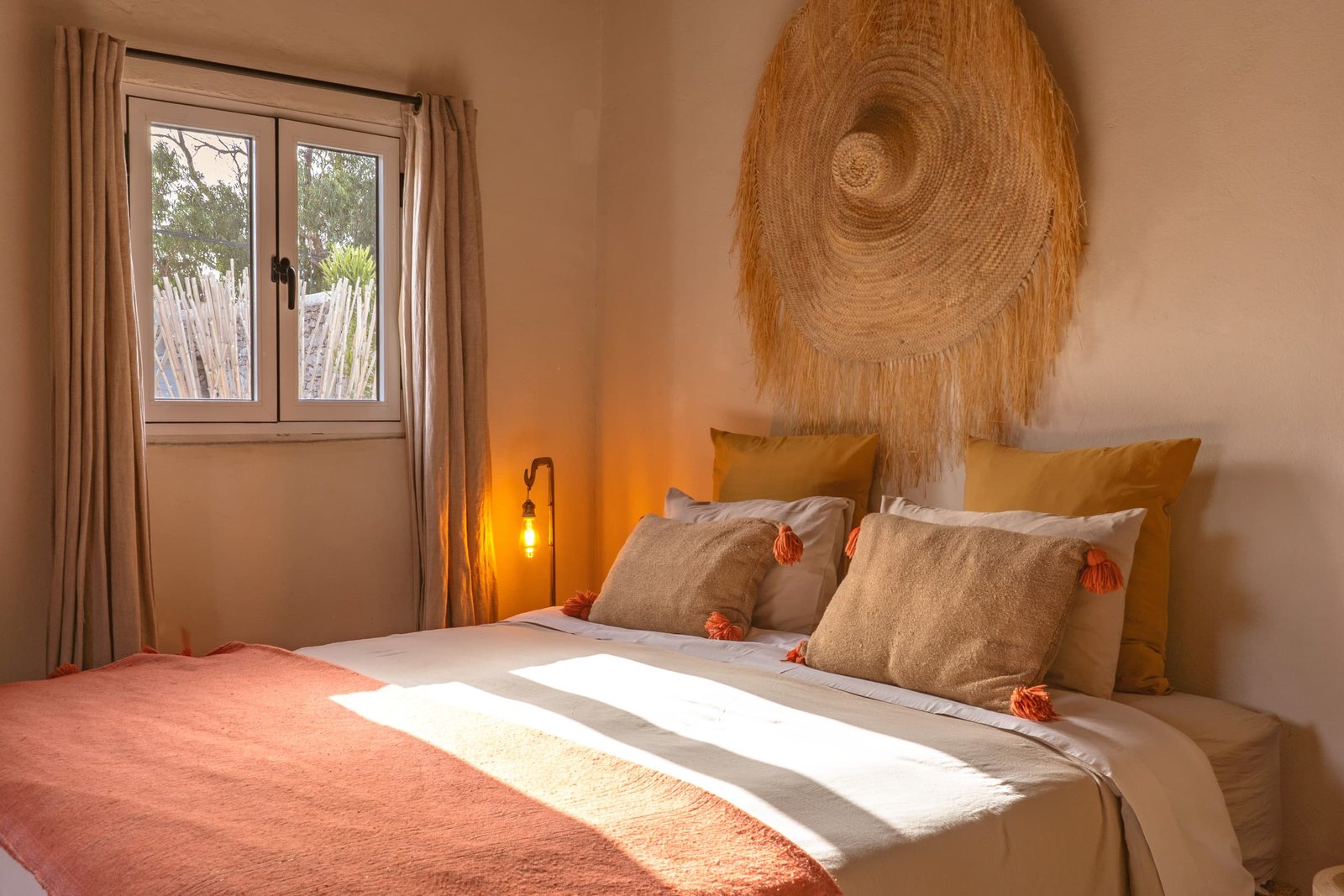 La chambre Bohème et sa fenêtre sur le jardin, deux lits réunis sous le disque de raphia