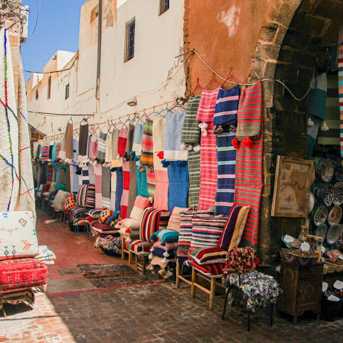 Une rue de la médina et ses terrasses, tapis et chaises sorties