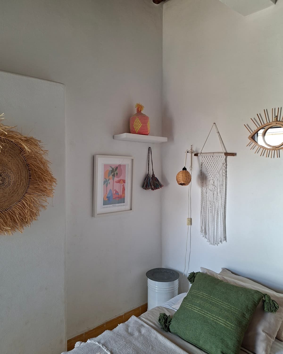 L’espace de vie de la Suite Bambou, chapeaux de paille et coussin vert