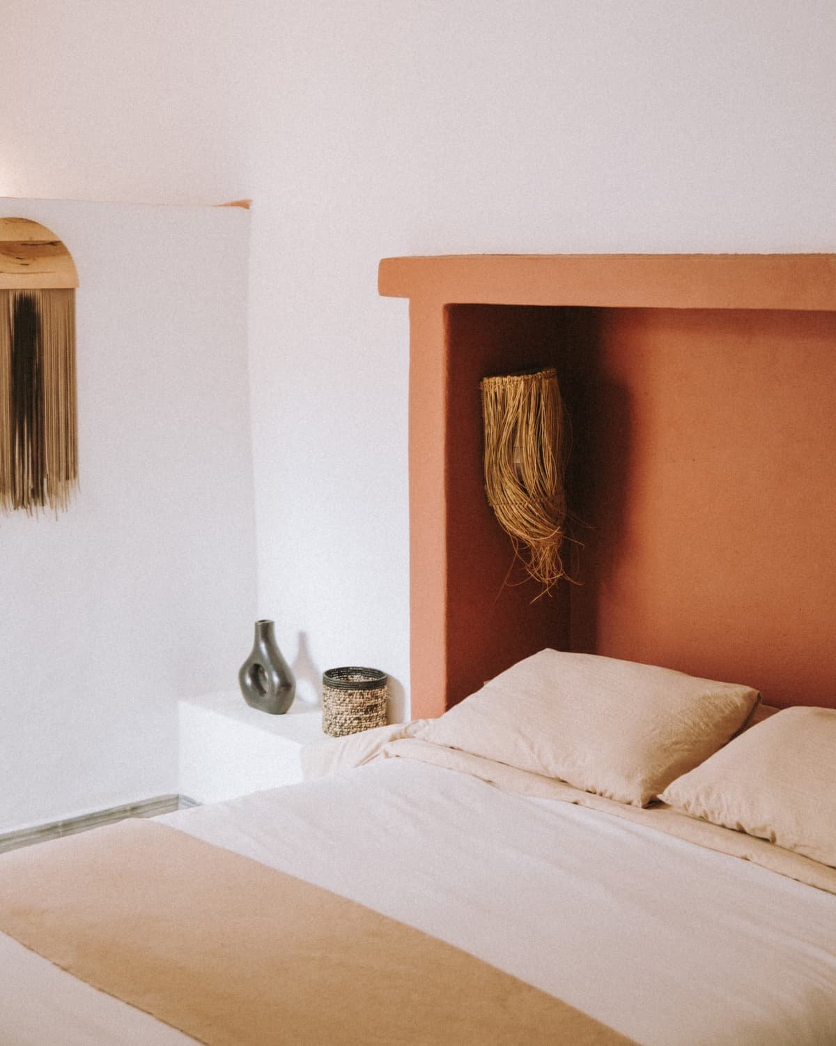 Le lit de la chambre Terracotta dans son alcôve de tadelakt, couverture beige