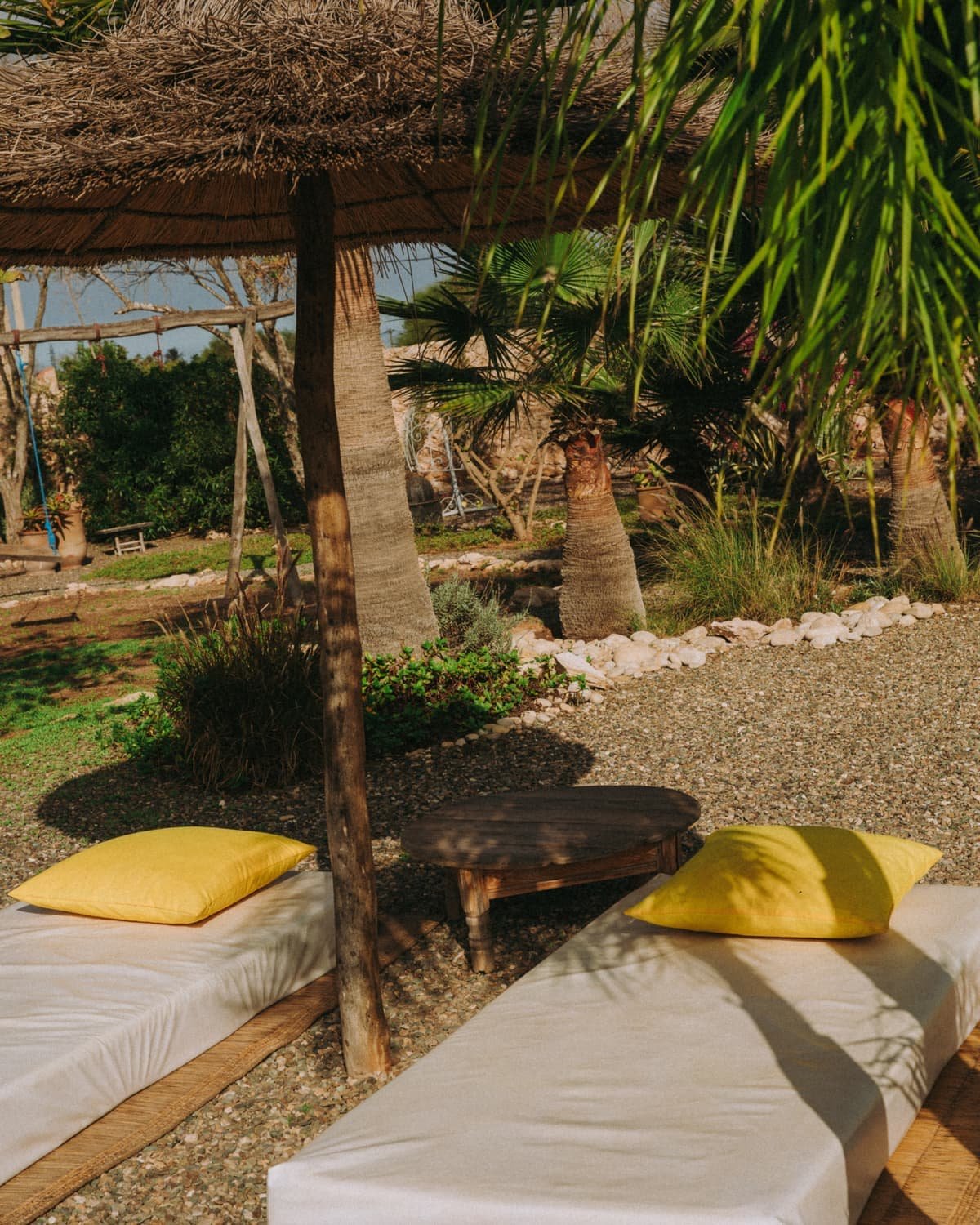 Coussins jaunes sur un lit de repos, dans le jardin de graviers