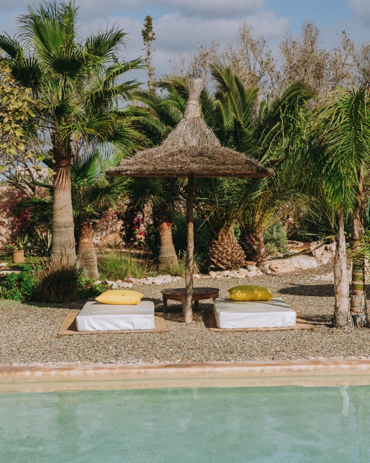 Parasols de paille et bains de soleil sous les palmiers