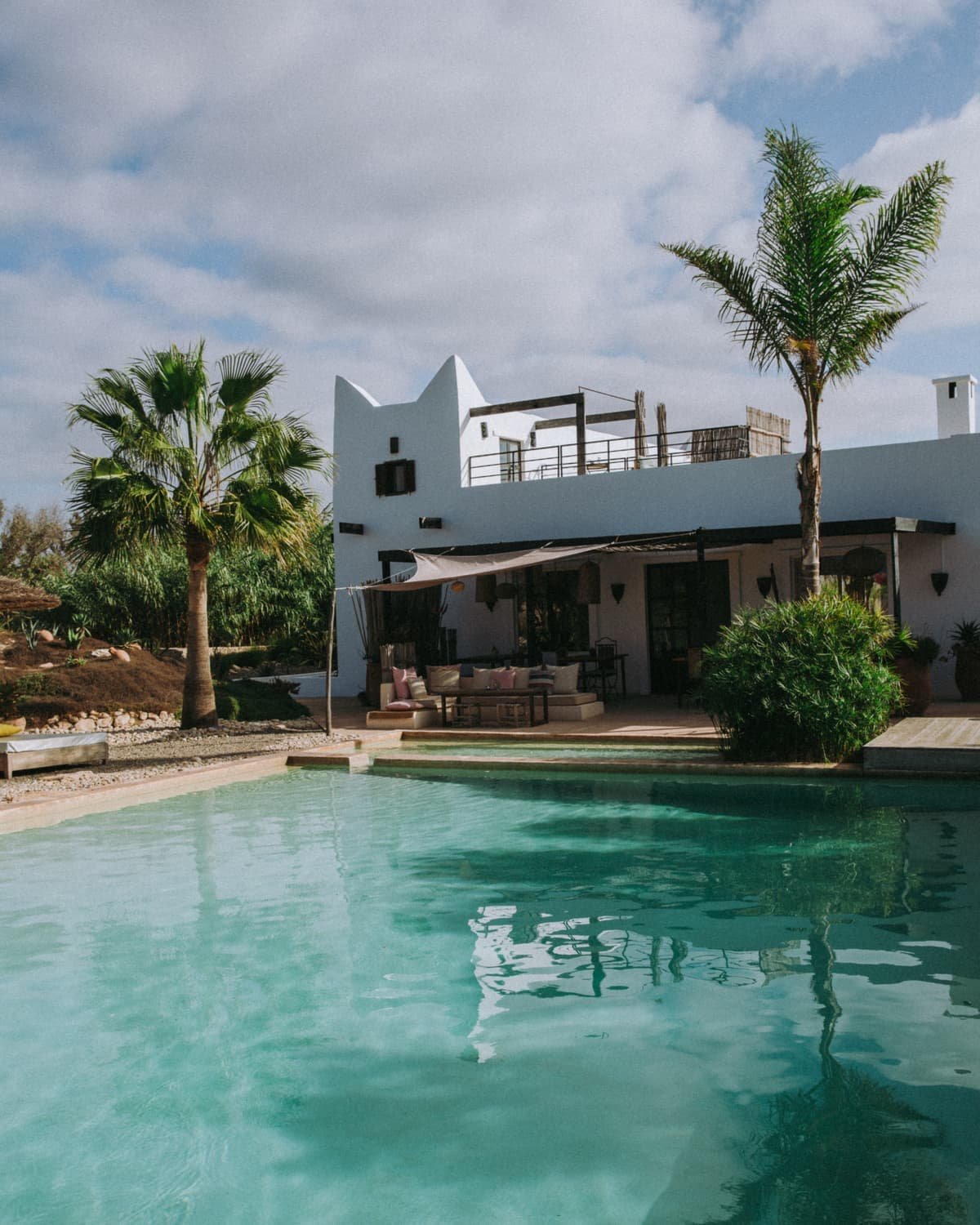 La maison blanche et sa terrasse a l’etage, vues depuis la piscine