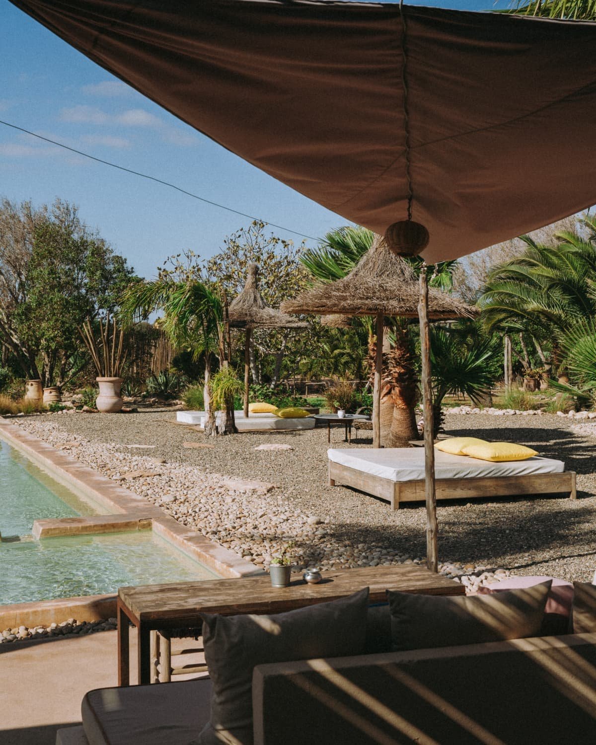 Lit de repos sous une toile tendue, face a la piscine