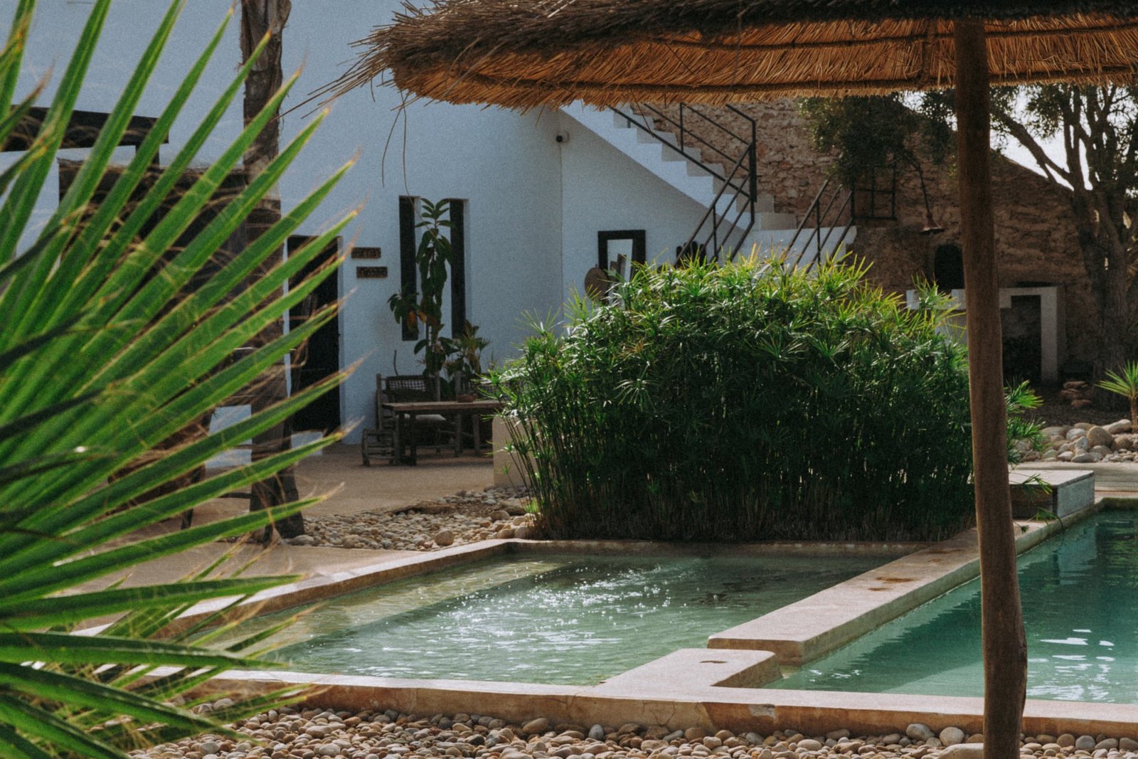 Parasol de paille et bain de soleil au bord de la piscine
