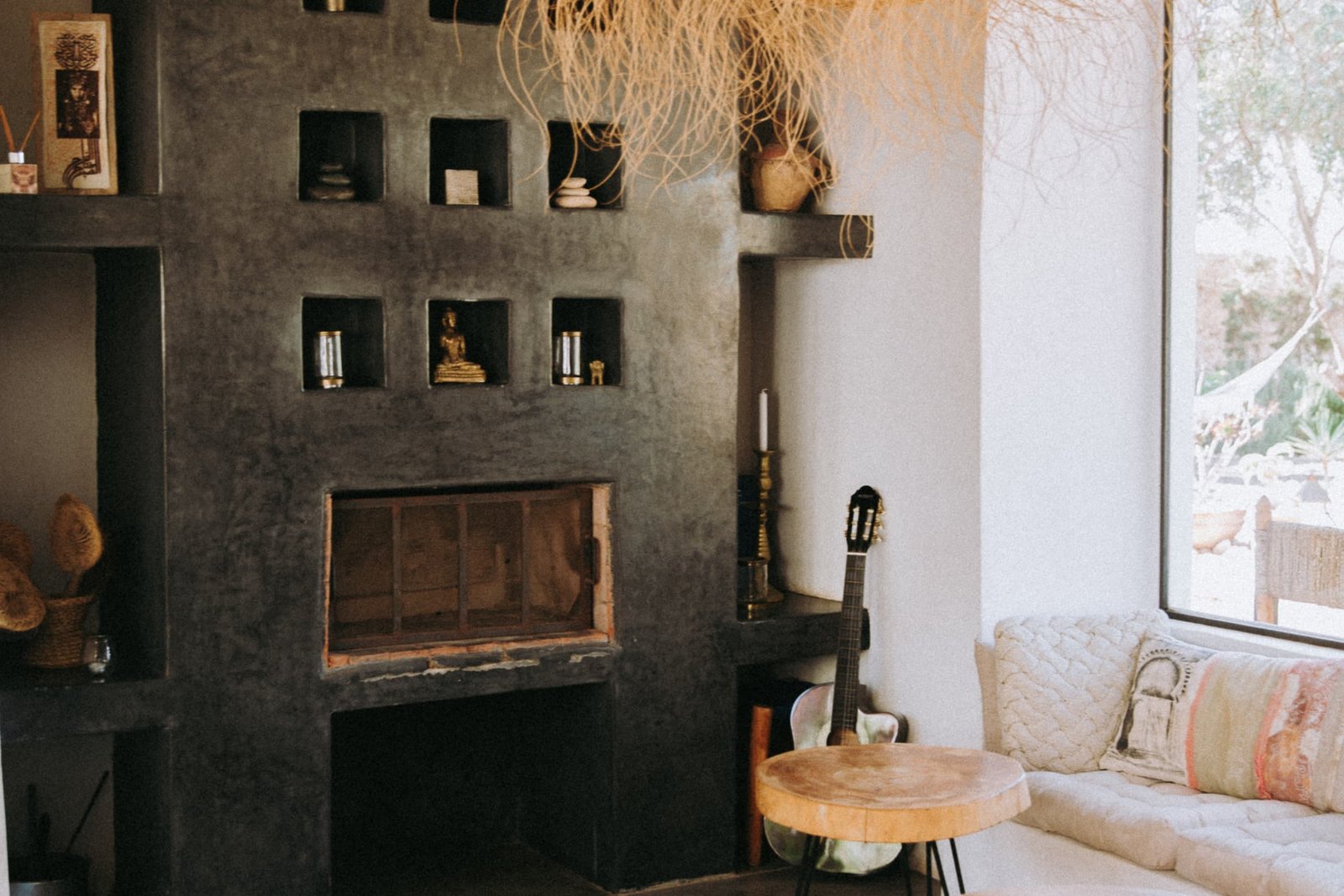 La cheminee du salon et ses niches, banquette basse et coussins