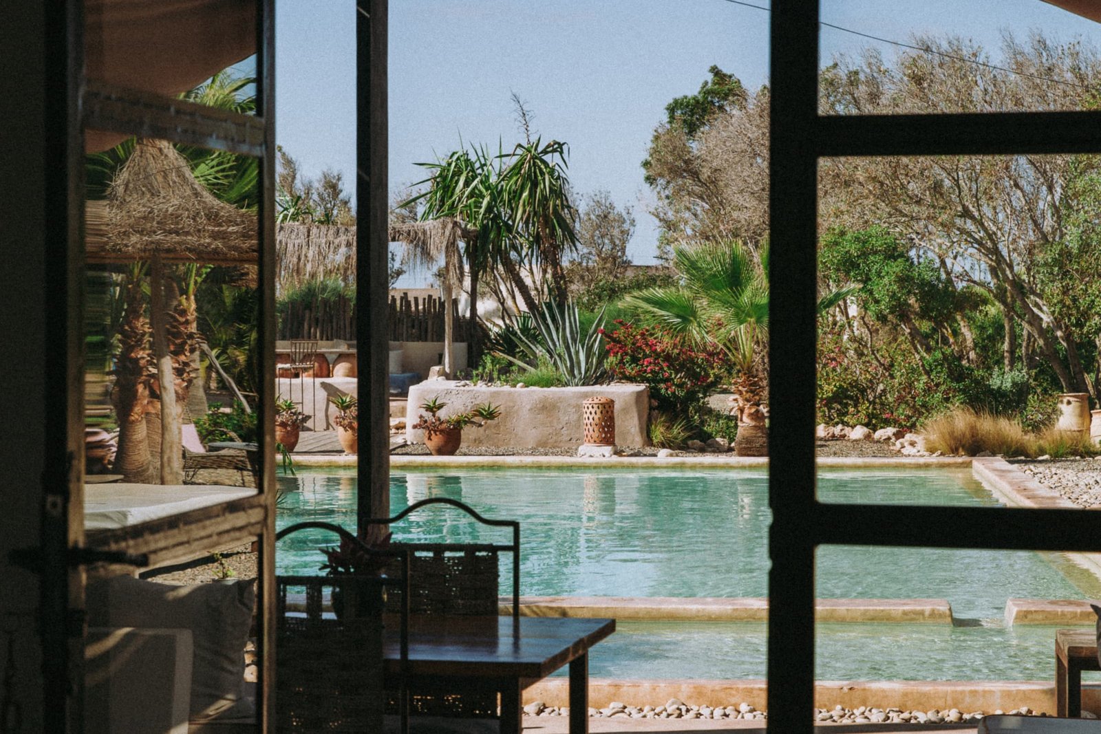 La veranda vitree, sa table et la vue sur la piscine