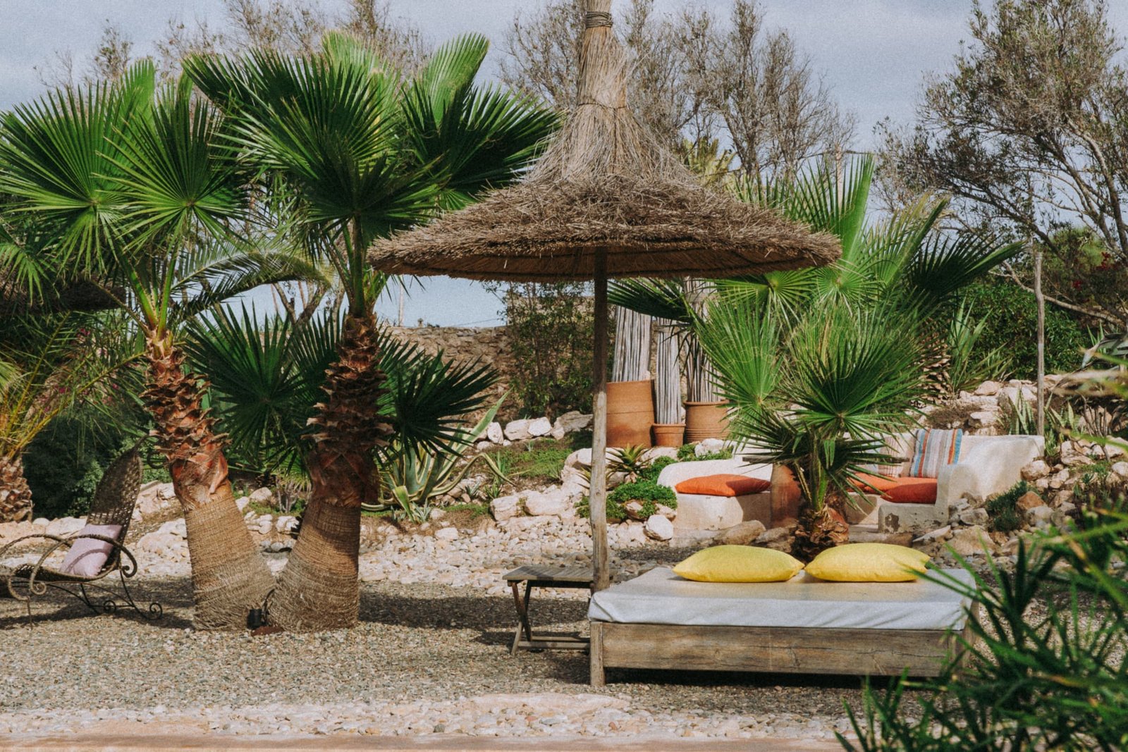 Bains de soleil sous les parasols de paille, entre les palmiers