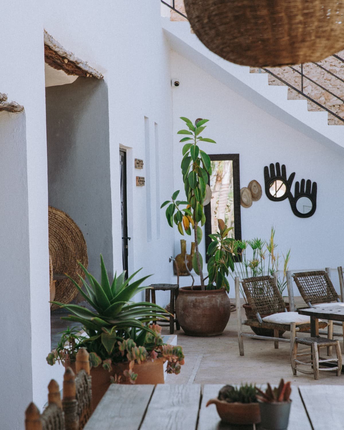 L’intérieur blanc de la maison, plantes en pot et grande table en bois