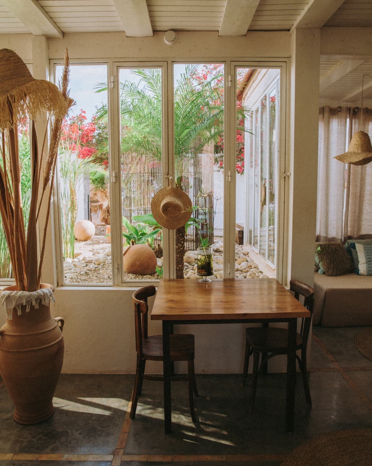 La grande table de la véranda, face aux fenêtres ouvertes sur le jardin